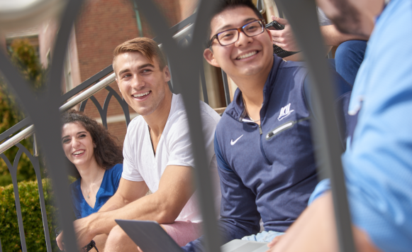 Three students sitting on stairs.