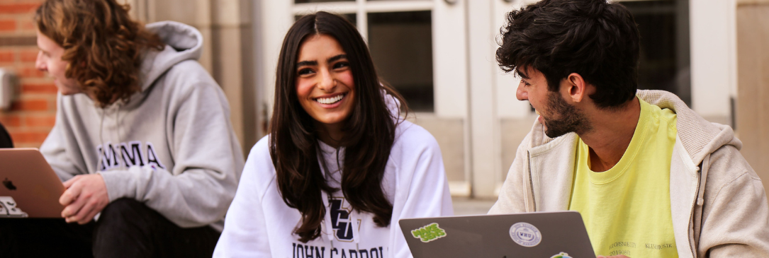 students working on school work outside of residence hall