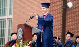 Tate Farinacci speaking at JCU's 2025 undergraduate commencement ceremony.